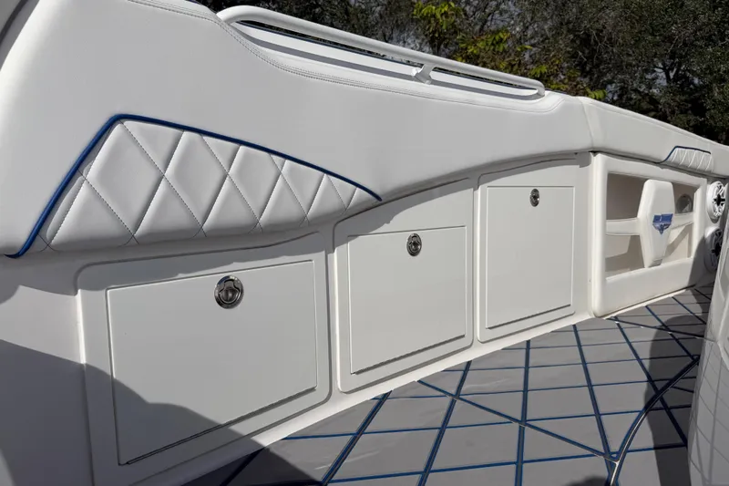  Yacht Photos Pics 2024 Deep Impact 399 Sport boat interior with white cushioned seating and storage compartments.