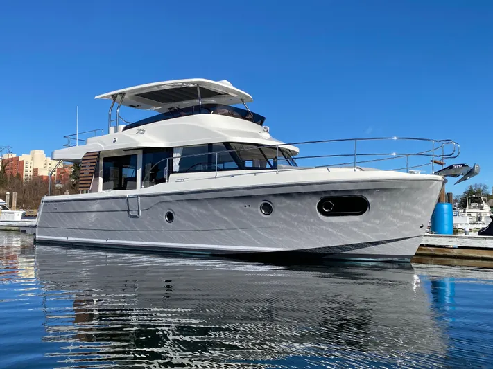 Yacht Photos Pics 2024 Beneteau Swift Trawler 48 docked in a marina on a sunny day.