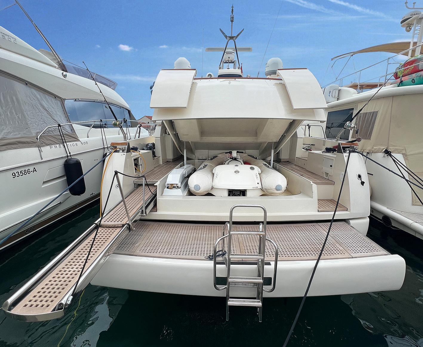 Luxury yacht Ilver Vista 58, 2002 model, docked with open stern and tender boat visible.