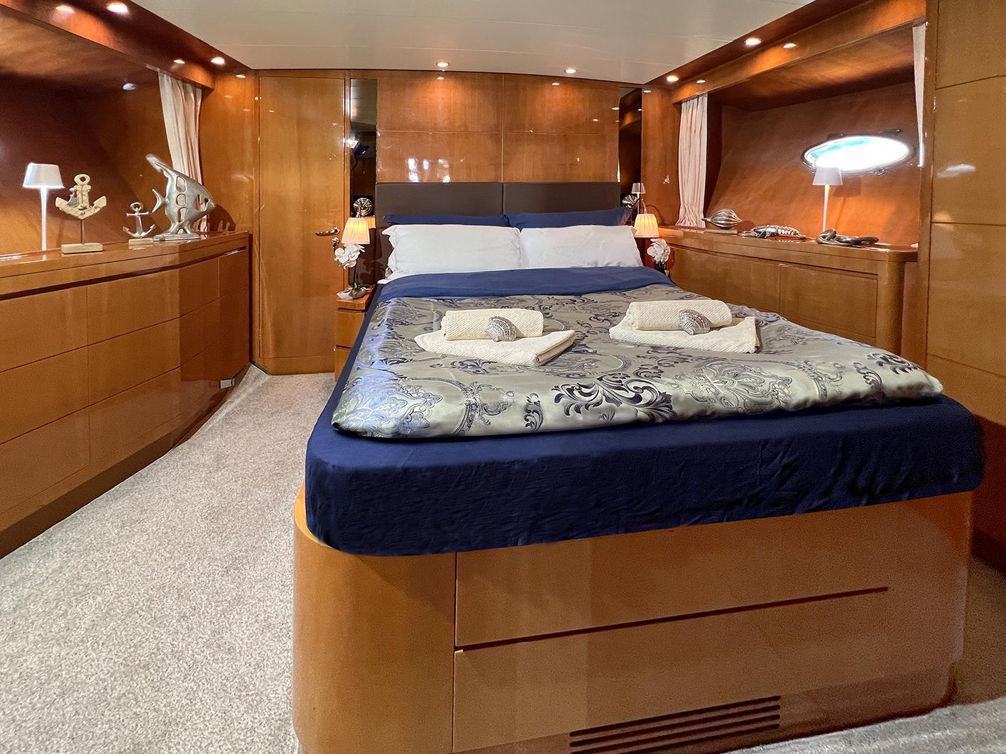 Luxurious bedroom interior of 2002 Ilver Vista 58 yacht with elegant wood paneling.