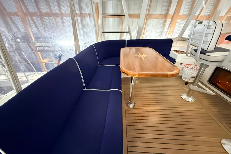 Ocean Osprey Yacht Photos Pics Luxurious 2006 Selene 57 yacht interior with blue seating and wooden table.