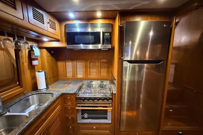 Ocean Osprey Yacht Photos Pics Luxurious 2006 Selene 57 yacht kitchen with stainless steel appliances and wooden cabinetry.