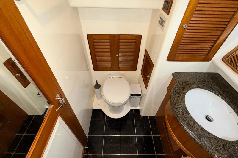 Ocean Osprey Yacht Photos Pics Luxury yacht bathroom with wooden accents, black tile floor, and modern fixtures, Selene 57, 2006.