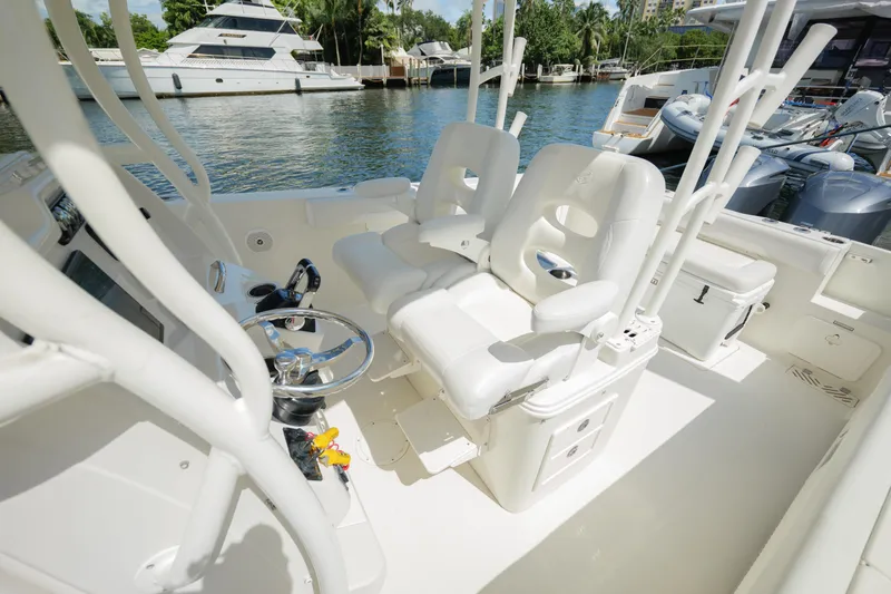  Yacht Photos Pics 2015 Sailfish 320 CC boat interior with white seating and steering wheel, docked near yachts.