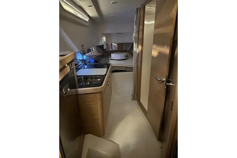  Yacht Photos Pics Luxurious interior of 2023 Nimbus C11 yacht with modern kitchen and cozy sleeping area.