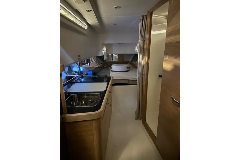  Yacht Photos Pics Interior of 2023 Nimbus C11 boat featuring a compact kitchen and cozy sleeping area.