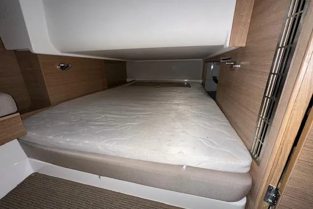  Yacht Photos Pics Cozy sleeping area in 2023 Nimbus C11 boat with wooden accents and comfortable mattress.