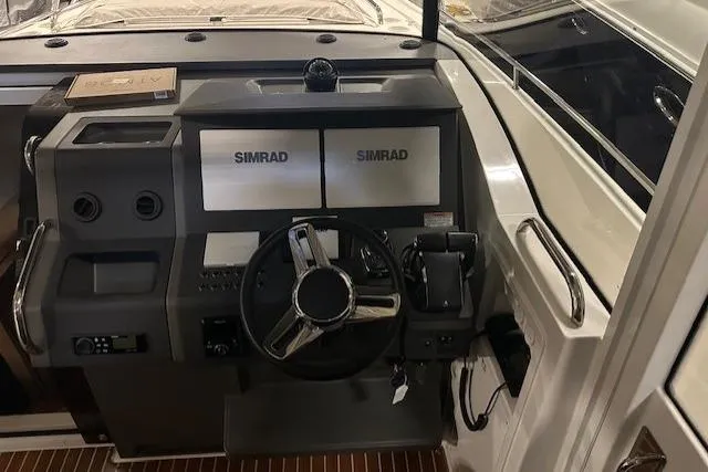  Yacht Photos Pics 2023 Nimbus C11 boat dashboard with dual Simrad displays and steering wheel.