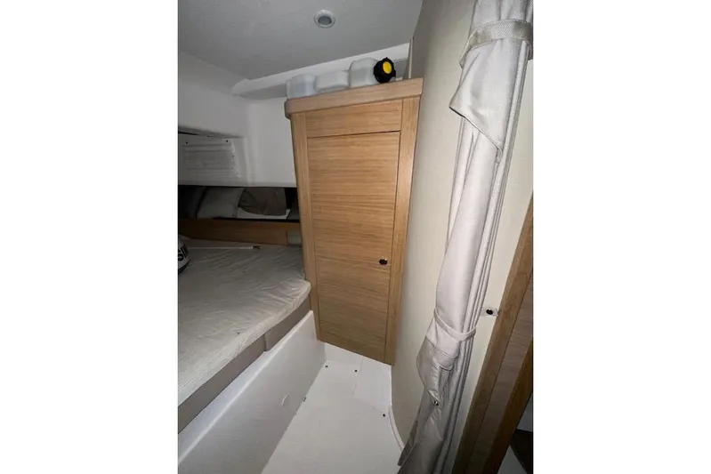  Yacht Photos Pics Interior of 2023 Nimbus C11 boat with wooden cabinetry and cozy sleeping area.
