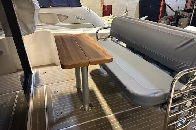  Yacht Photos Pics 2023 Nimbus C11 boat interior with wooden table and cushioned seating.