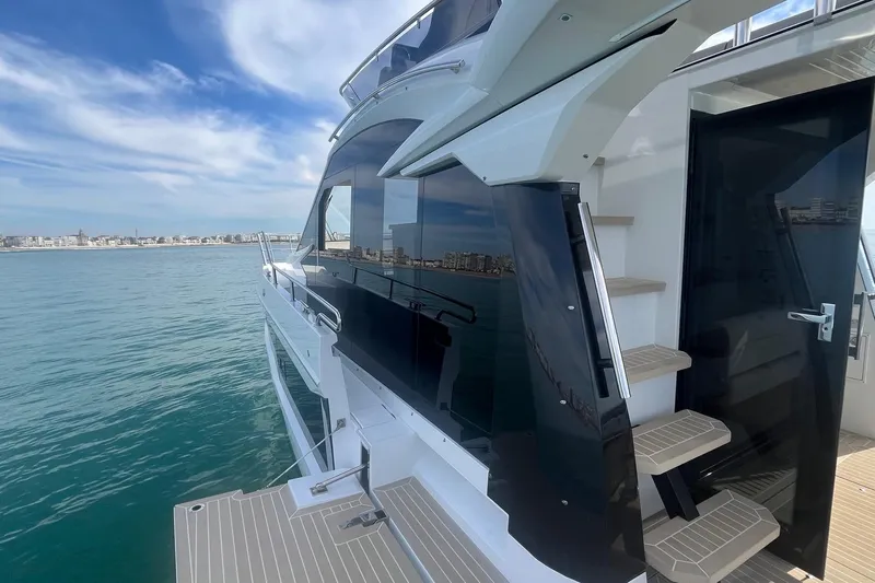  Yacht Photos Pics 2026 Galeon 400 Fly yacht with sleek design, docked by the sea under a blue sky.