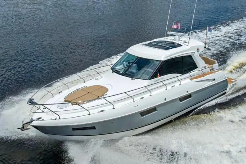  Yacht Photos Pics 2015 Cruisers Cantius yacht cruising on open water, displaying sleek design and American flag.