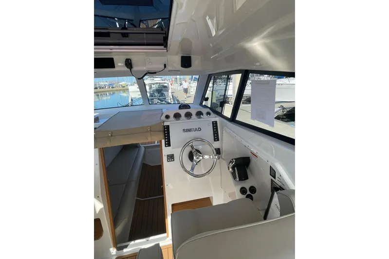  Yacht Photos Pics Interior view of 2024 Protector 330 Targa boat, featuring modern controls and steering wheel.