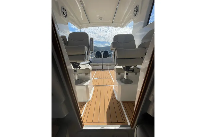  Yacht Photos Pics 2024 Protector 330 Targa boat interior with twin 400 HP engines, featuring sleek seating and wood flooring.