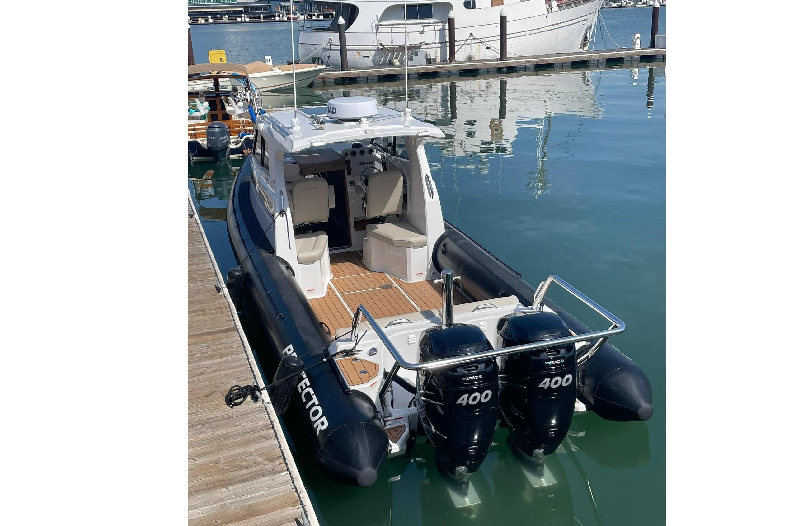 2024 Protector 330 Targa boat with 400 HP engines docked.