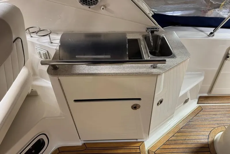  Yacht Photos Pics 2011 Sea Ray 310 Sundancer boat kitchenette with sink and grill on teak flooring.
