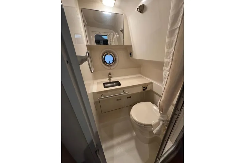  Yacht Photos Pics 2011 Sea Ray 310 Sundancer bathroom with sink, toilet, and porthole window.