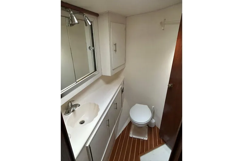 Nelmar Yacht Photos Pics Bathroom interior of 1988 Ocean Yachts 48 Super Sport with sink, toilet, and wood flooring.