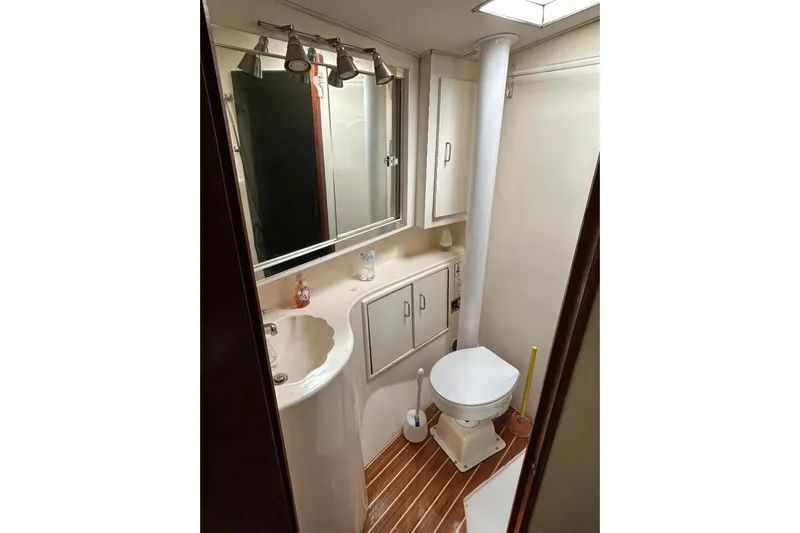 Nelmar Yacht Photos Pics Bathroom interior of 1988 Ocean Yachts 48 Super Sport, featuring sink, toilet, and mirror.