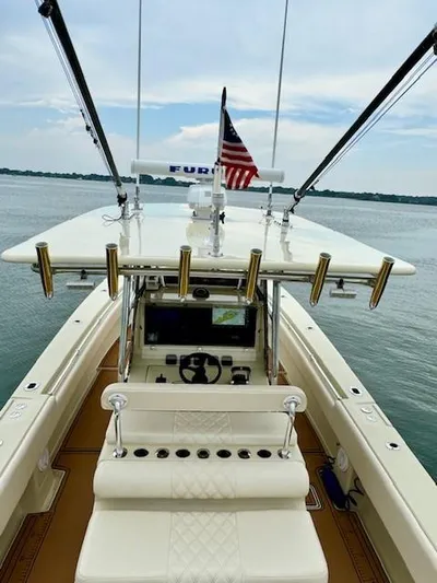 Wild Life Yacht Photos Pics 2010 Contender 39 Tournament boat with fishing rod holders and American flag on calm water.