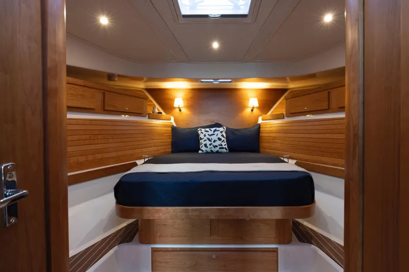 Ready For Customization Yacht Photos Pics Luxurious cabin interior of 2027 Back Cove 412 yacht with cozy bed and wooden accents.
