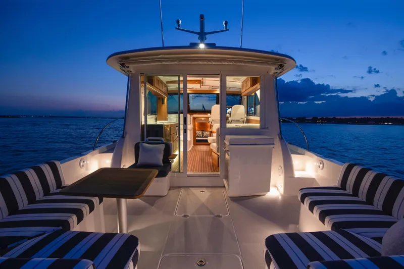 Ready For Customization Yacht Photos Pics Luxurious 2027 Back Cove 412 yacht interior at sunset, featuring elegant seating and ambient lighting.