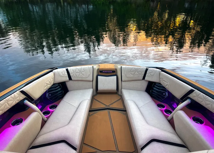  Yacht Photos Pics 2026 Nautique Paragon G25 boat interior with luxurious seating and ambient lighting on a serene lake.