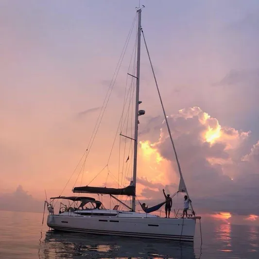 Mi Akumal Yacht Photos Pics Sailboat Jeanneau Sun Odyssey 40.3, 2011 model, at sunset with vibrant sky.
