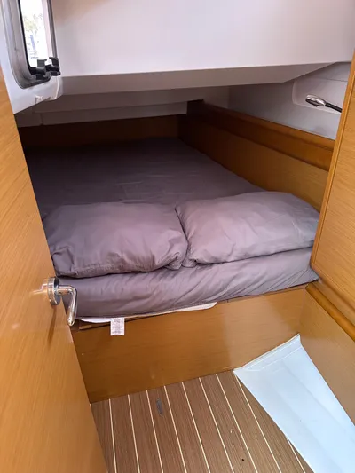 Mi Akumal Yacht Photos Pics Cozy cabin interior of 2011 Jeanneau Sun Odyssey 40.3 with wooden finish and bedding.