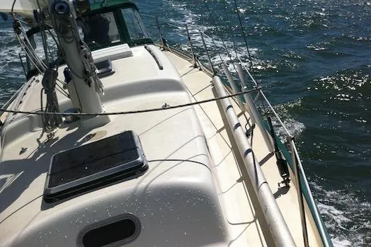 Sailing on a 1968 Spencer 35 yacht, gliding through sparkling ocean waters.