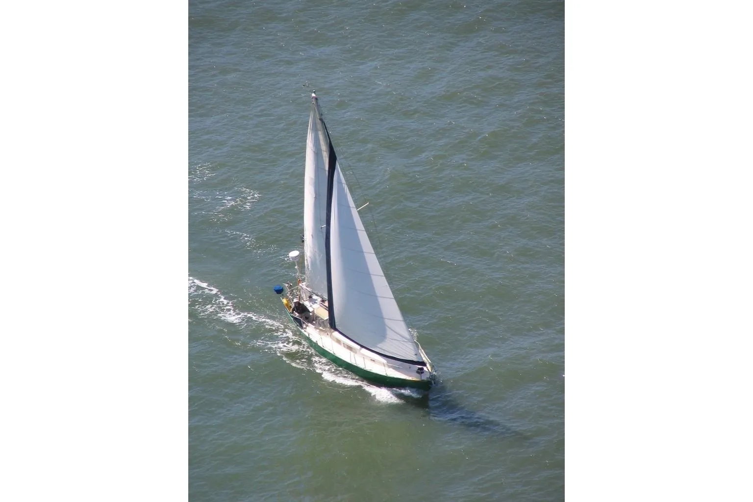 Aerial view of a 1968 Spencer 35 sailboat navigating through open water.