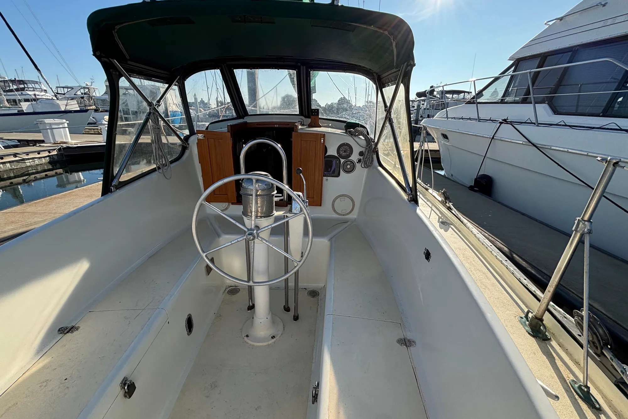 1968 Spencer 35 sailboat cockpit with steering wheel, docked at marina.