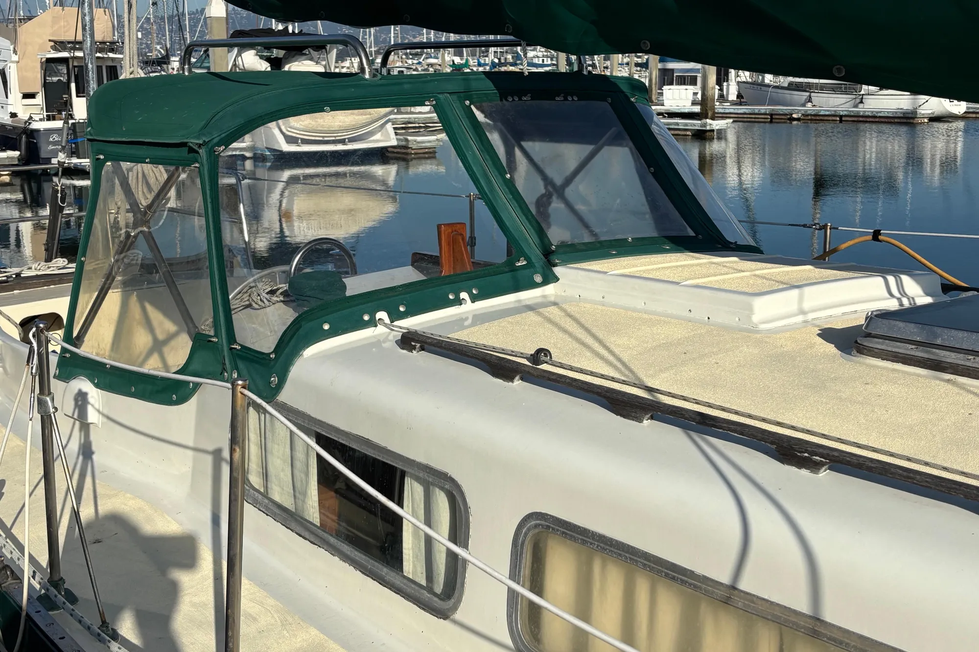 1968 Spencer 35 sailboat with green canopy docked in marina.