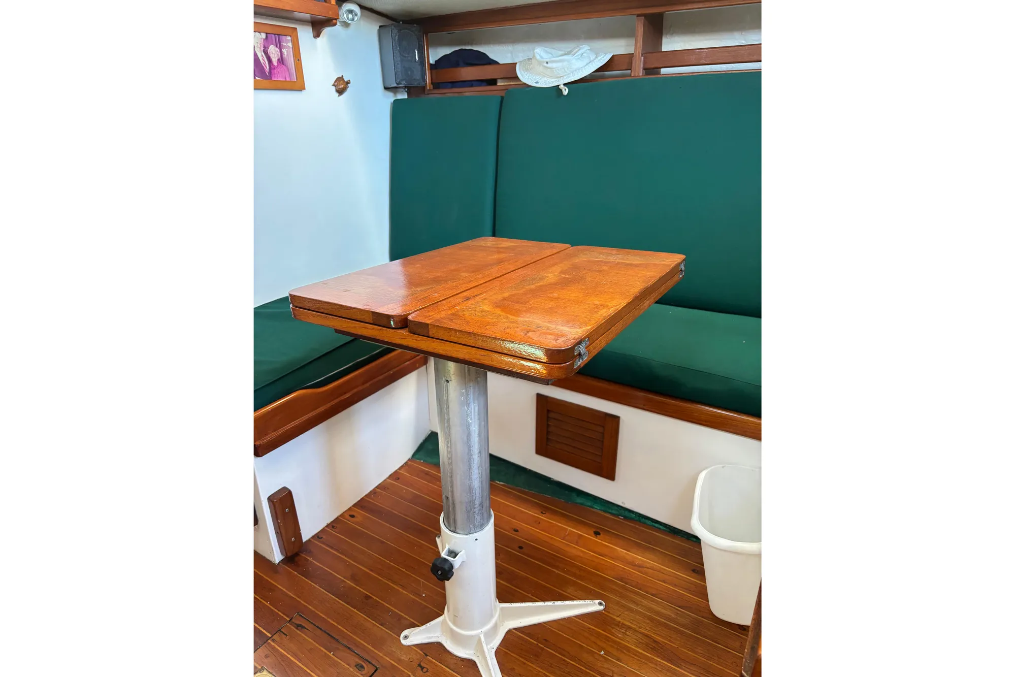 1968 Spencer 35 interior with wooden table and green seating.