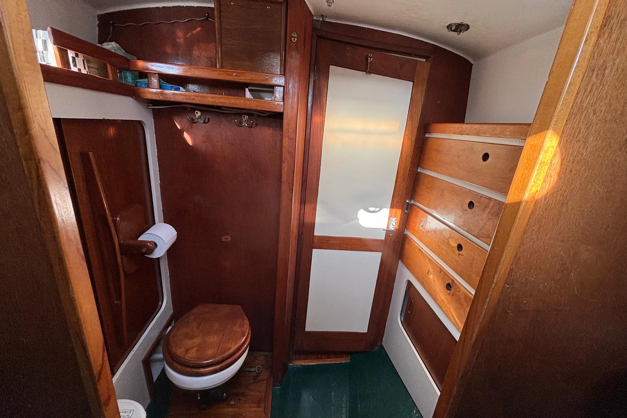 Vintage 1968 Spencer 35 yacht bathroom with wooden cabinetry and compact design.