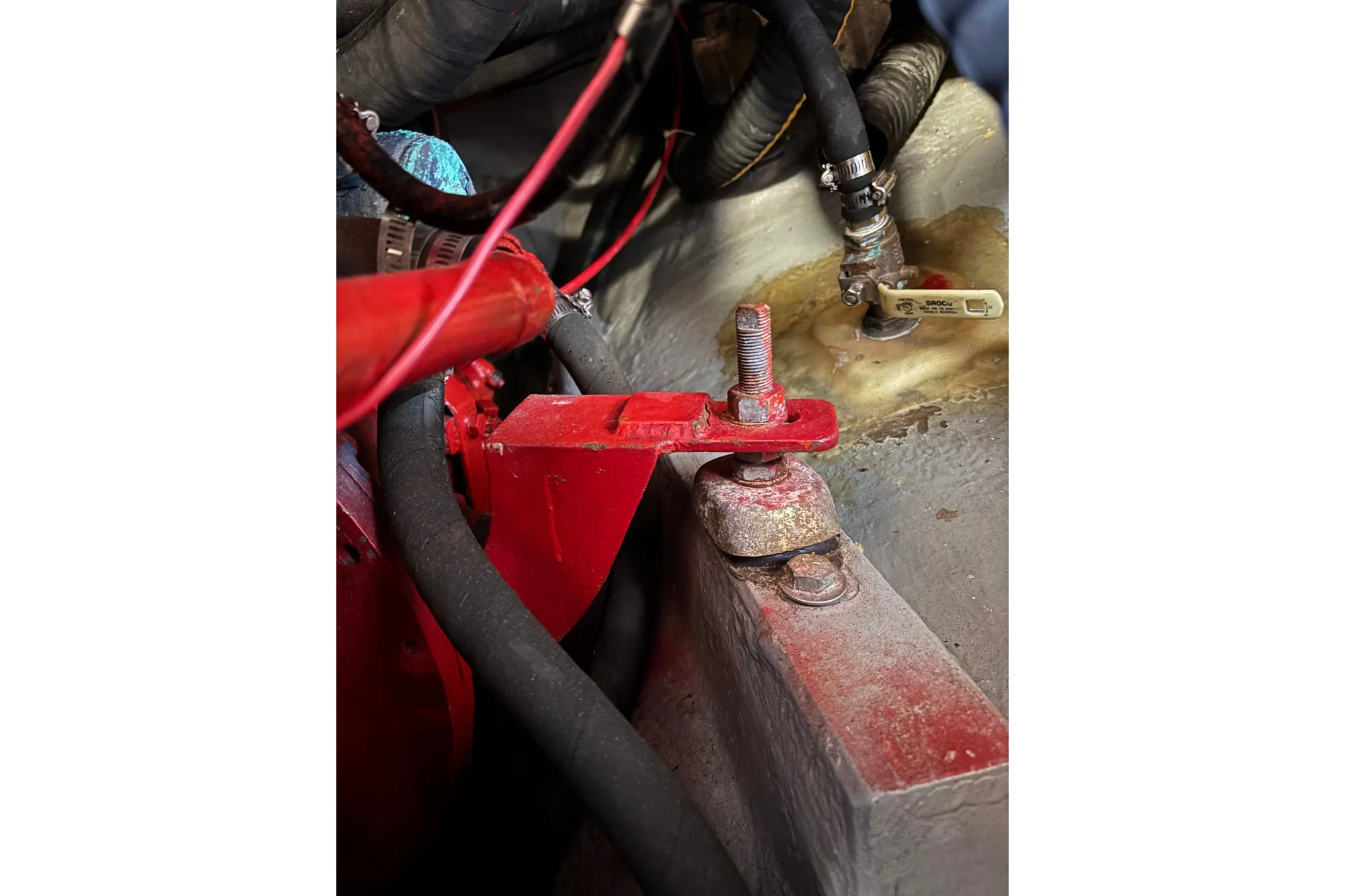 Close-up of a 1968 Spencer 35 engine component with red metal parts and hoses.