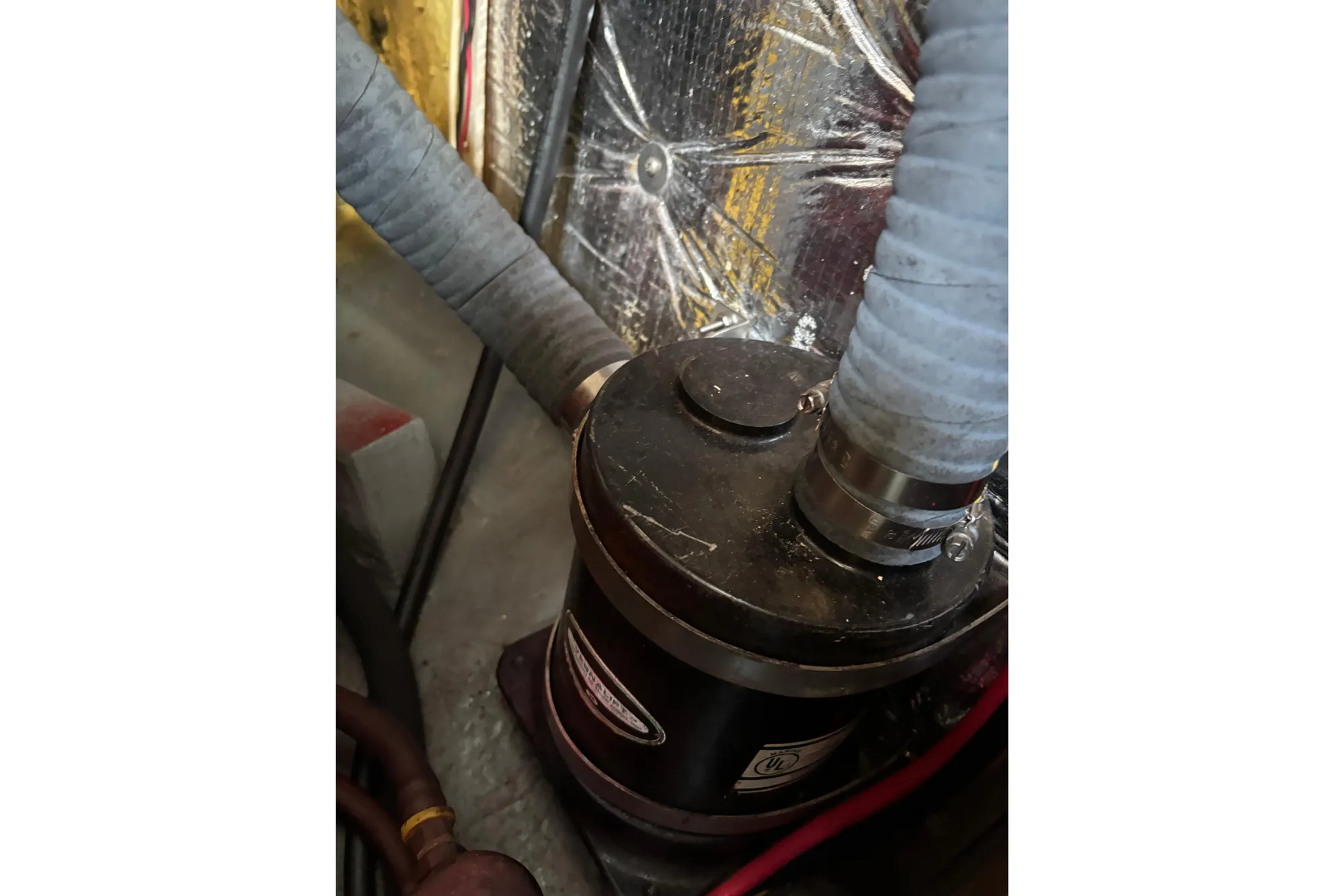 1968 Spencer 35 engine compartment with hoses and metallic insulation.