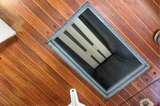 Wooden deck with open hatch on 1968 Spencer 35 boat.