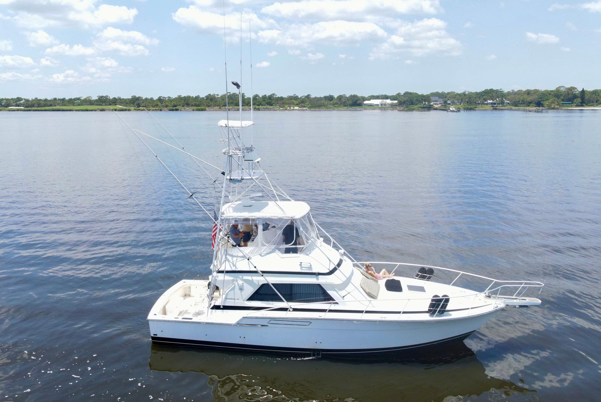 1988 Bertram 43 Convertible yacht on calm water under a clear sky.