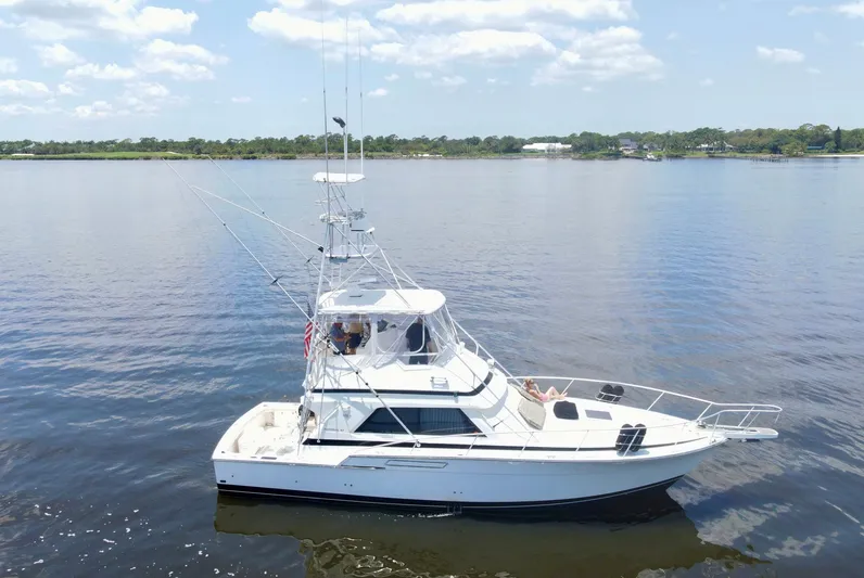 Islander 7 Yacht Photos Pics 1988 Bertram 43 Convertible yacht on calm water under a clear sky.