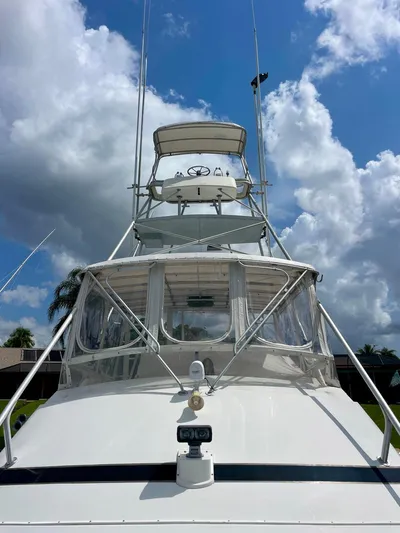 Islander 7 Yacht Photos Pics 1988 Bertram 43 Convertible yacht under a bright blue sky with clouds.