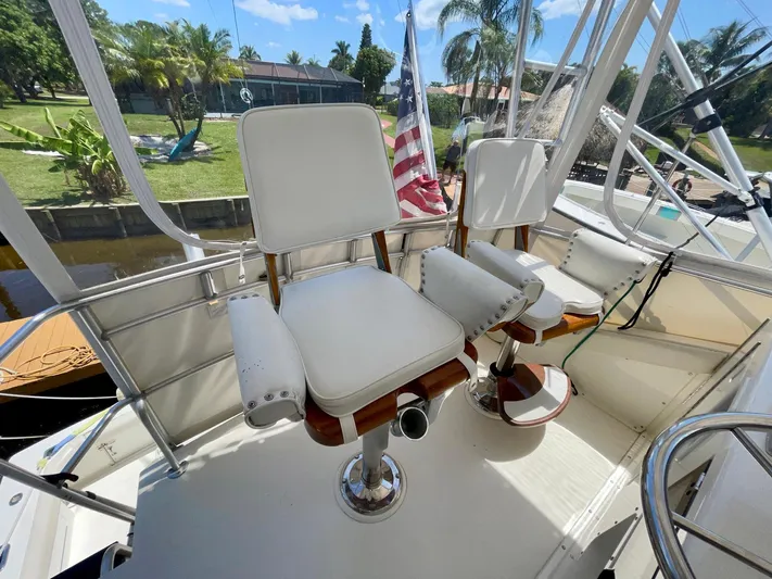 Islander 7 Yacht Photos Pics 1988 Bertram 43 Convertible boat helm with white captain chairs and American flag.