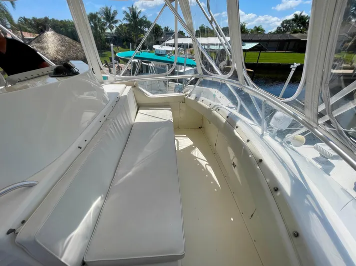 Islander 7 Yacht Photos Pics 1988 Bertram 43 Convertible boat interior with white seating and clear enclosure.