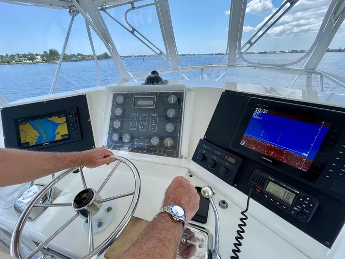 Islander 7 Yacht Photos Pics 1988 Bertram 43 Convertible helm with navigation screens and steering wheel on open water.