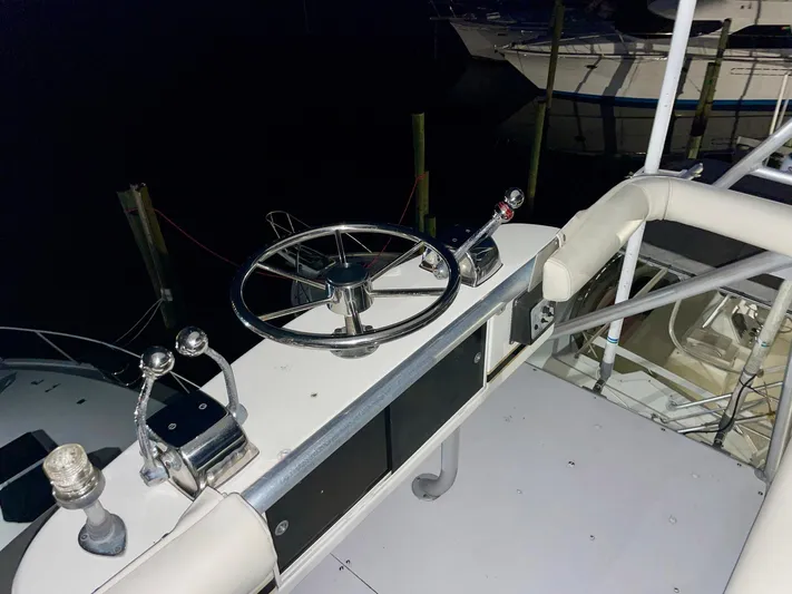 Islander 7 Yacht Photos Pics 1988 Bertram 43 Convertible yacht helm with steering wheel and controls at night.