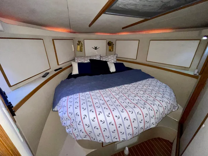 Islander 7 Yacht Photos Pics 1988 Bertram 43 Convertible cabin with cozy bed and nautical-themed bedding.