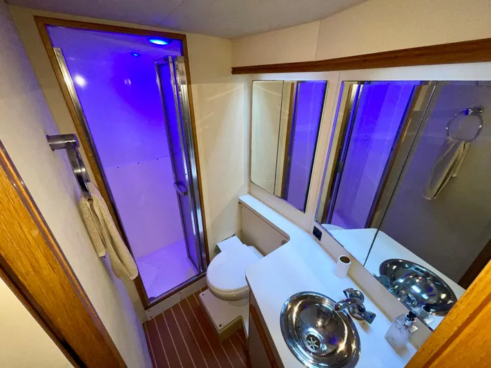 Islander 7 Yacht Photos Pics Luxurious bathroom in a 1988 Bertram 43 Convertible yacht with modern fixtures and blue lighting.