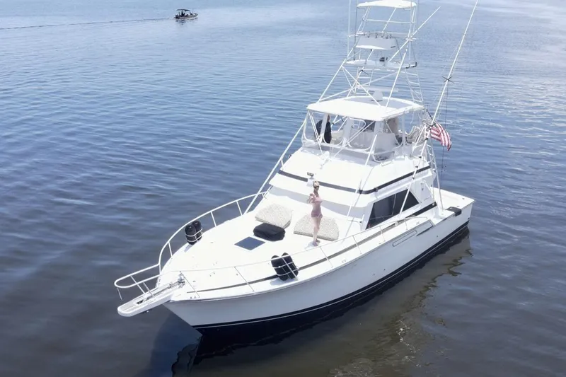 Islander 7 Yacht Photos Pics 1988 Bertram 43 Convertible yacht cruising on calm waters with American flag.
