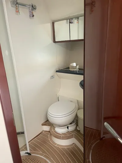 Princess V65 | 65ft | 2004 Yacht Photos Pics 2004 Princess V65 yacht bathroom with toilet, mirror, and wooden flooring.