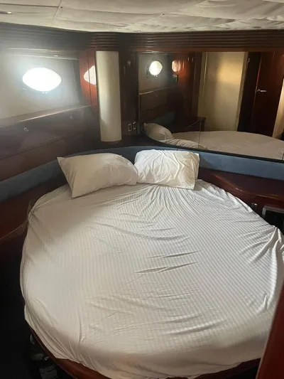Princess V65 | 65ft | 2004 Yacht Photos Pics Luxurious cabin interior of 2004 Princess V65 yacht with round bed and porthole windows.